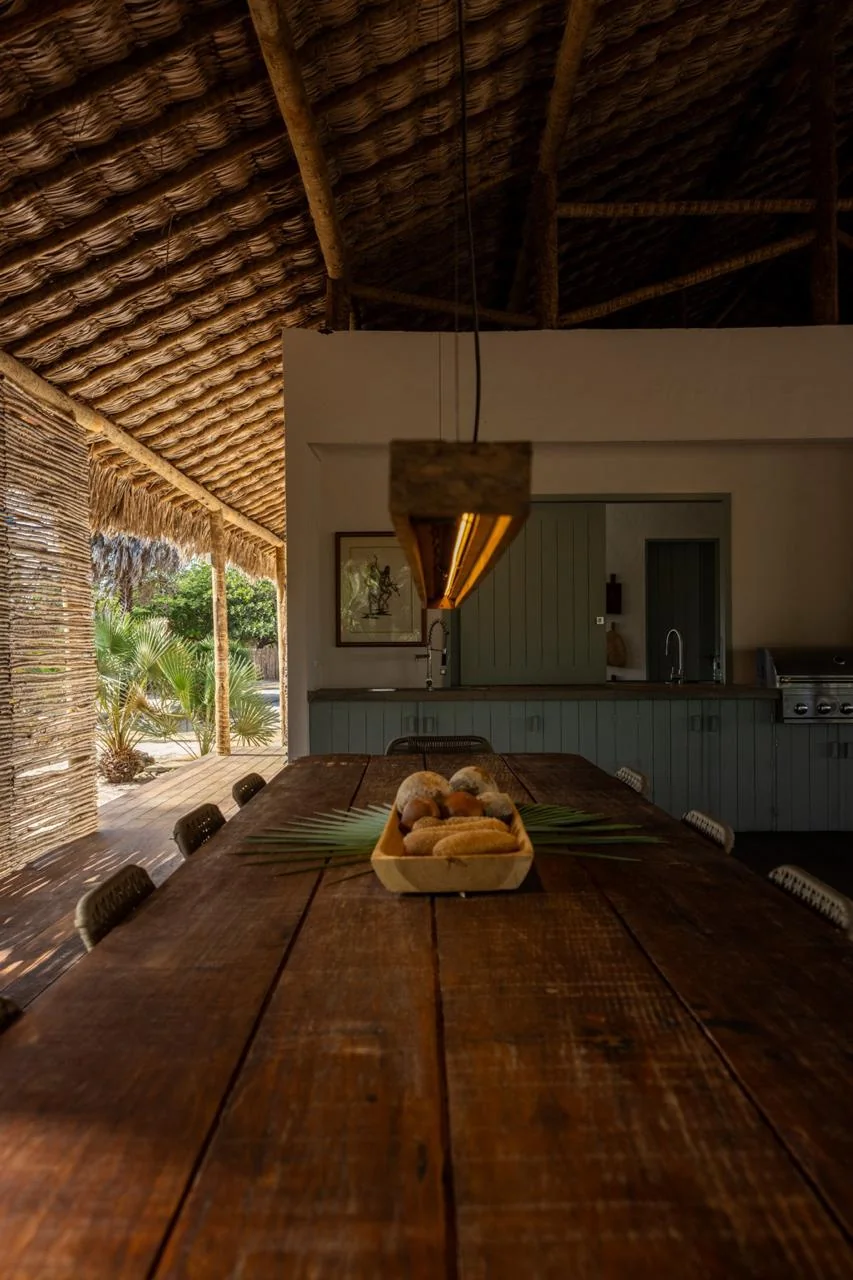 Mesa de madeira diante da cozinha da hospedaria