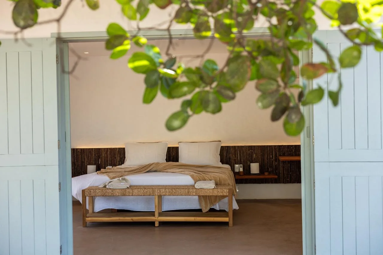 Quarto aberto para a varanda por portas azuis
