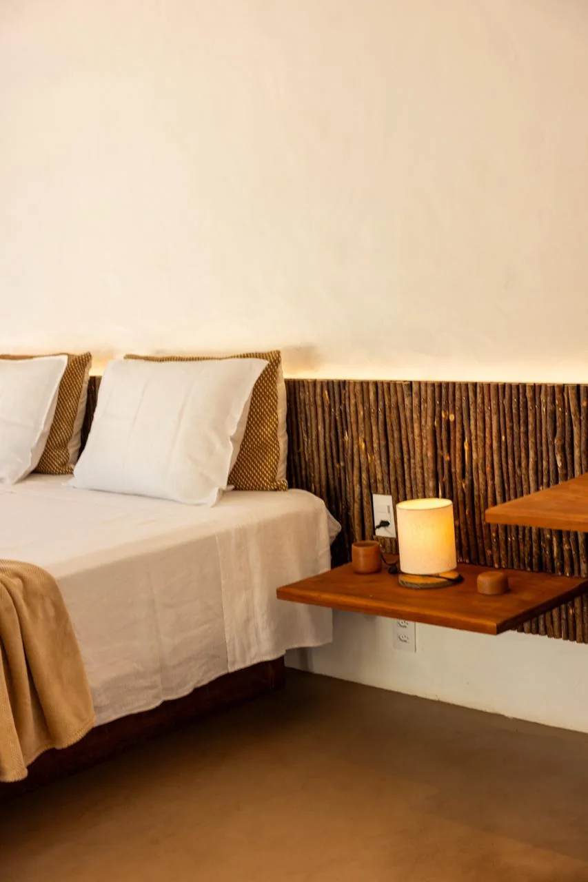 Quarto com cabeceira de madeira e iluminação suave